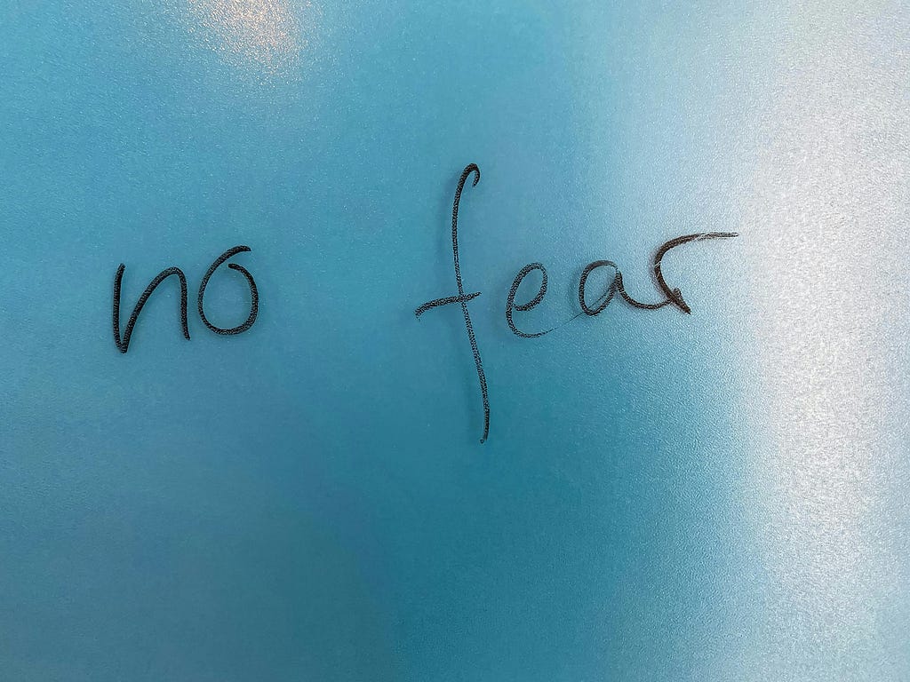 The words ‘no fear’ handwritten in black marker on a blue background.